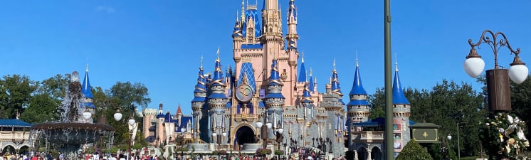 Cinderella's castle in Disney World Orlando, Florida. Castle is pink and blue and the sky is a clear blue