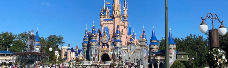 Cinderella's castle in Disney World Orlando, Florida. Castle is pink and blue and the sky is a clear blue
