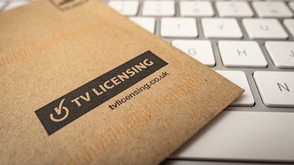 TV Licensing envelope on top of computer keyboard.