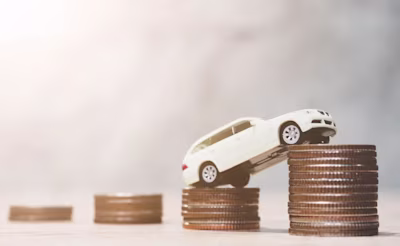 Picture of a toy car on top of two piles of coins.
