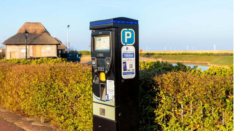 Parking meter in a countryside car park with a river behind it. 