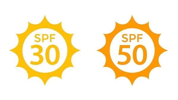 Two symbols that appear on sun cream bottles showing the SPF, or sun protection factor, usually found on the front. They are circular icons designed to look like the sun, with rays around them, with one saying "SPF 30" and one "SPF 50".