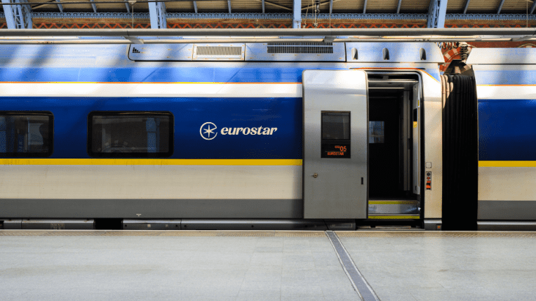 A blue and yellow Eurostar train at a station, with the door open