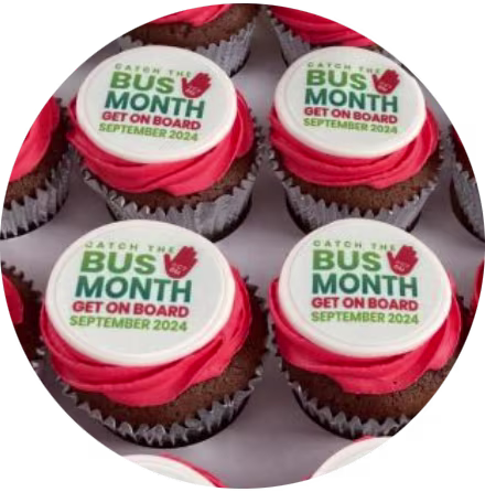 Cupcakes with red icings and white discs that read 'Catch the Bus Month'.