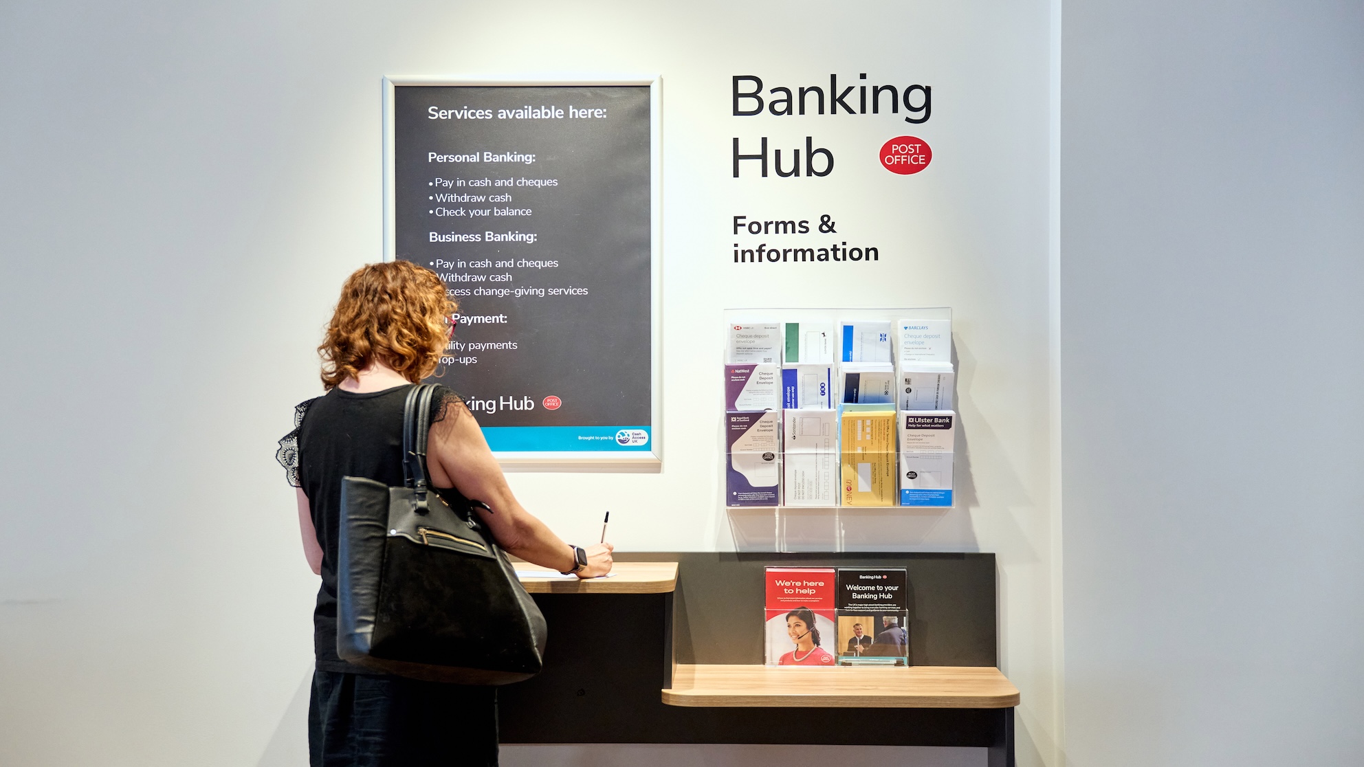 Woman filling in a form at a stand in a Banking Hub. 