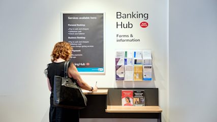 Woman filling in a form at a stand in a Banking Hub.