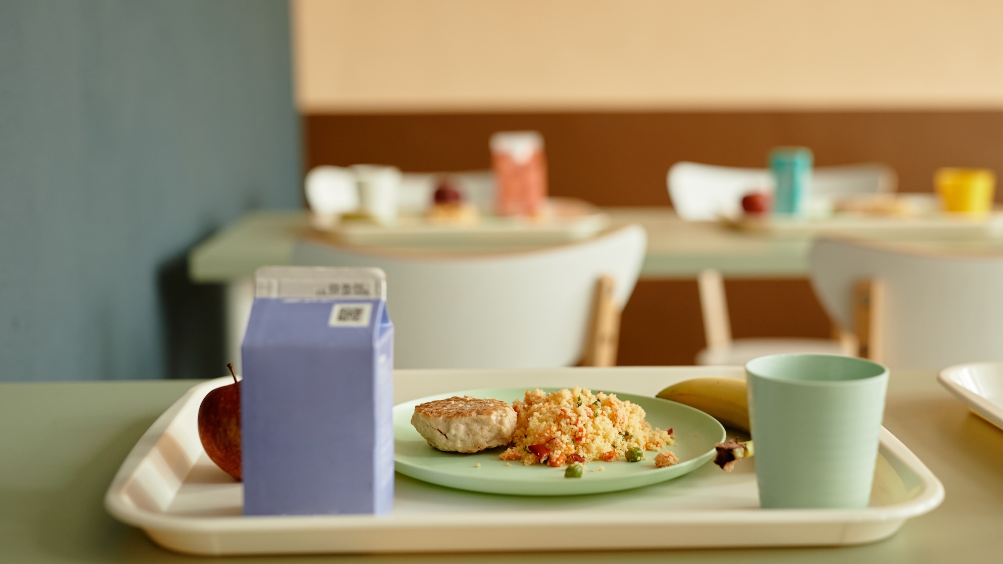 Plastic tray with plate of food and juice box on a canteen table