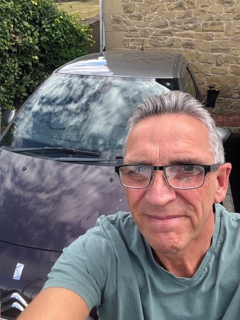Images shows John taking a selfie in front of his Citroen car