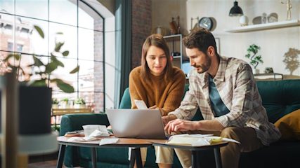 A young couple sorting out their finances on a laptop.