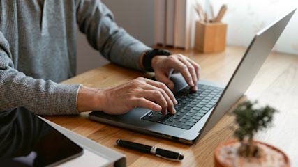 Close up of man's hands typing on laptop