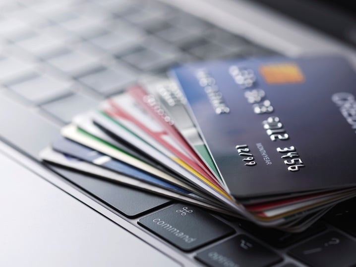 A stack of payment cards on a laptop keyboard