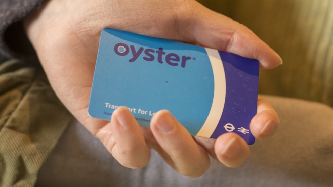 Oyster card held in the palm of someone's hand.