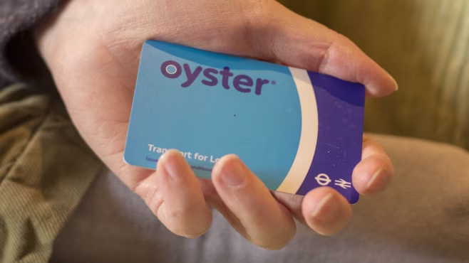 Oyster card held in the palm of someone's hand.