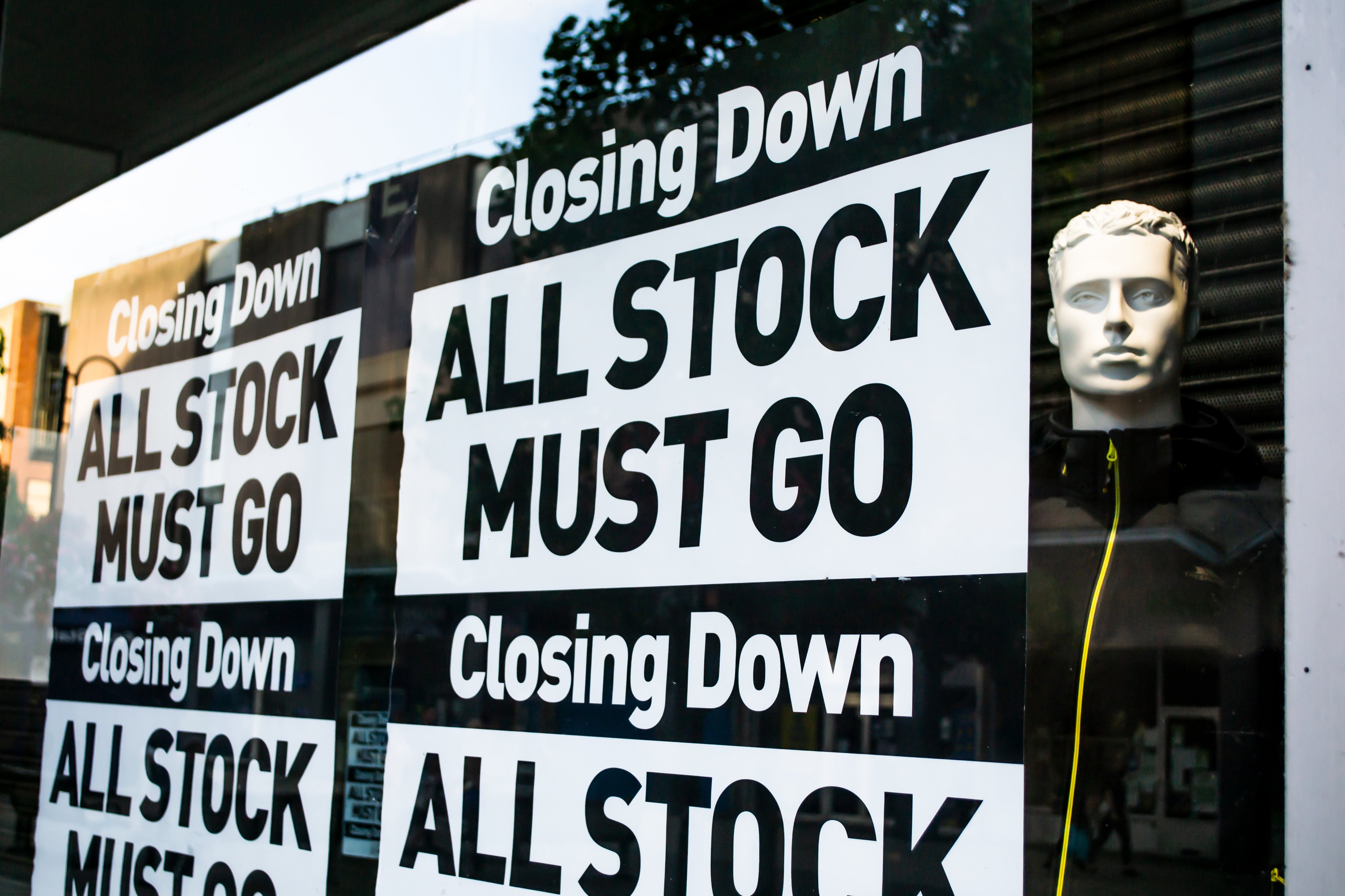 Shop signs saying "Closing down. All stock must go."