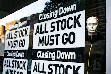 Shop signs saying "Closing down. All stock must go."