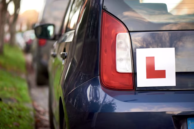 Close-up of a learner's L plate on the back of a car.