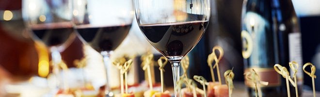 Glasses of red wine on a table.