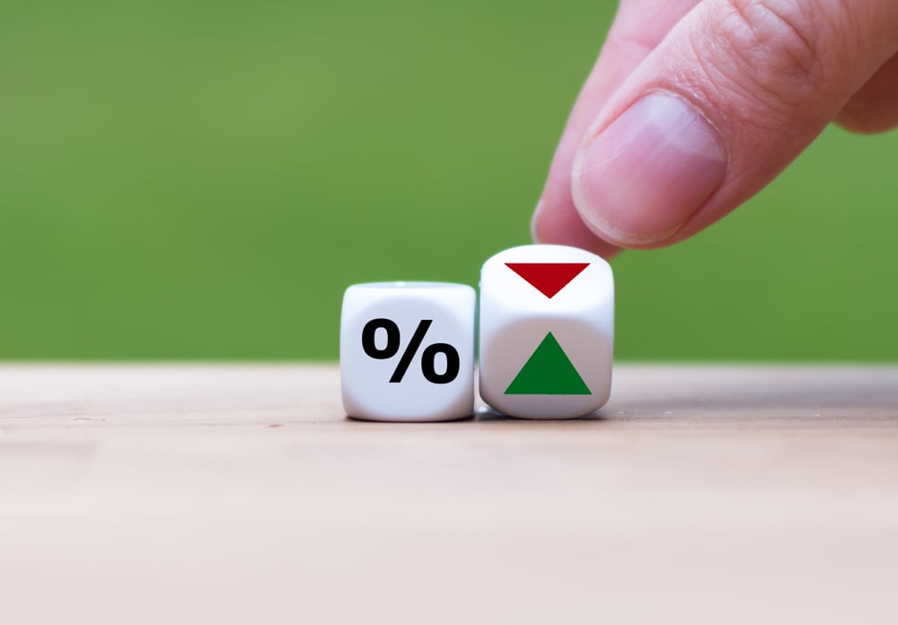 Two dice, one with a percentage symbol, and the other showing two sides, one with a green triangle and the other with a red downwards-facing triangle.