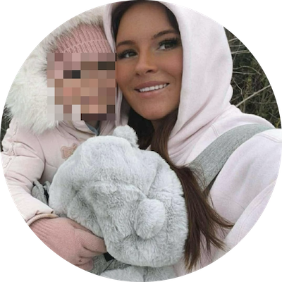 A woman dressed in pink holding a young child in a parka