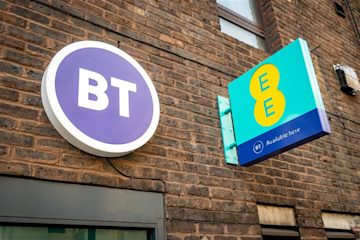 BT and EE signs on a brick wall (presumably above a retail shop).