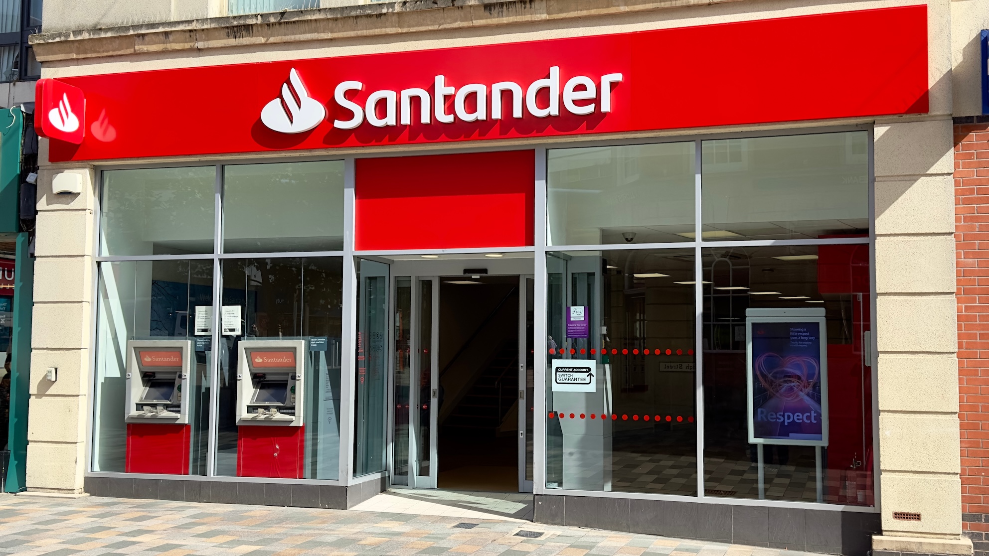 The outside of a Santander bank branch on a sunny day.