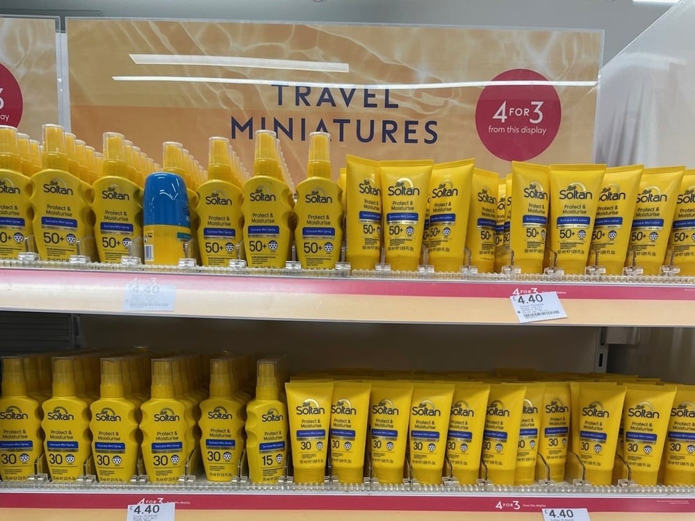 An in-store Boots display of different types of Soltan sun cream. It's below a sign reading: "Travel miniatures. Four for three from this display."