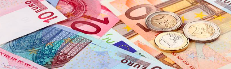 A close-up of some euro notes with some coins lying on top.