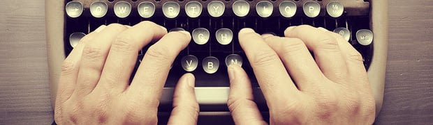 fingers typing on typewriter