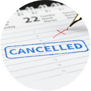 Close up of a calendar with a 'cancelled' stamp on it and a pen writing a red cross above it.