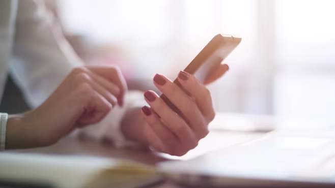 Picture of a woman holding her phone in one hand