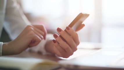 Picture of a woman holding her phone in one hand