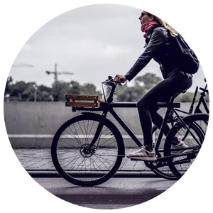 Woman on a hybrid bicycle cycling along a road.