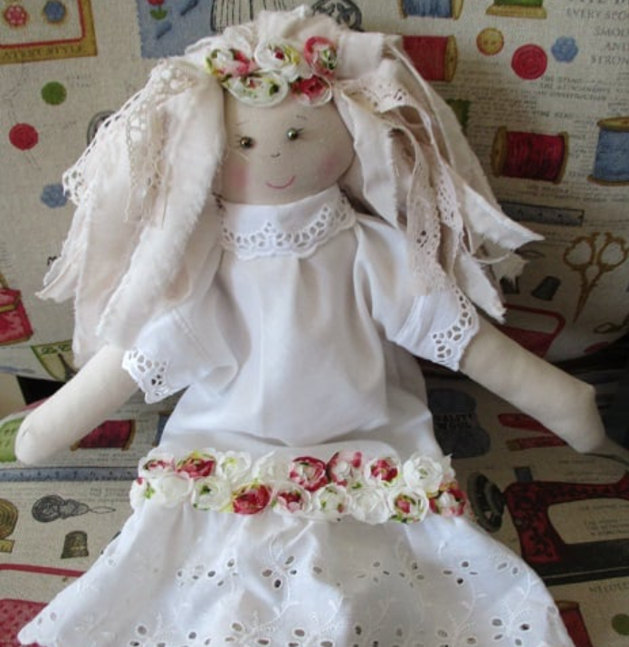 A rag doll in a white dress