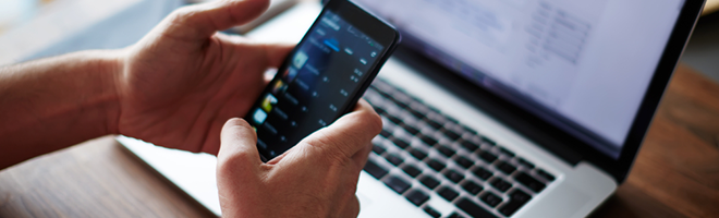 guy on phone while using laptop