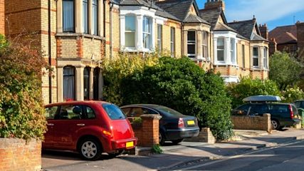 Row of brick semis with cars parked on the driveways