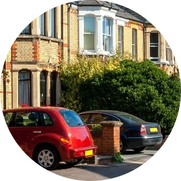 Row of brick semis with cars parked on the driveways