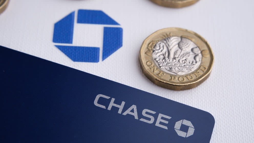 A Chase bank card with blue logo next to a one pound coin.