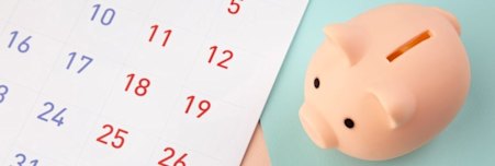A piggy bank next to a calendar
