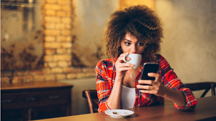 hero-homepage-woman-drinking-coffee-mobile-phone-smartphone-cafe-restaurant.png