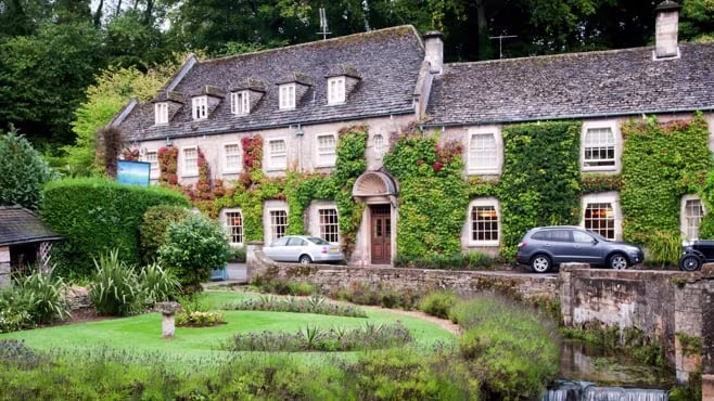 Old-fashioned holiday cottage covered in climbing plants.