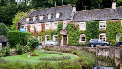 Old-fashioned holiday cottage covered in climbing plants.