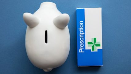 A piggy bank next to an NHS prescription