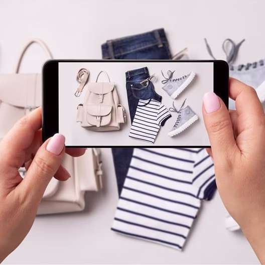 Someone taking a photo of some clothes to sell online.