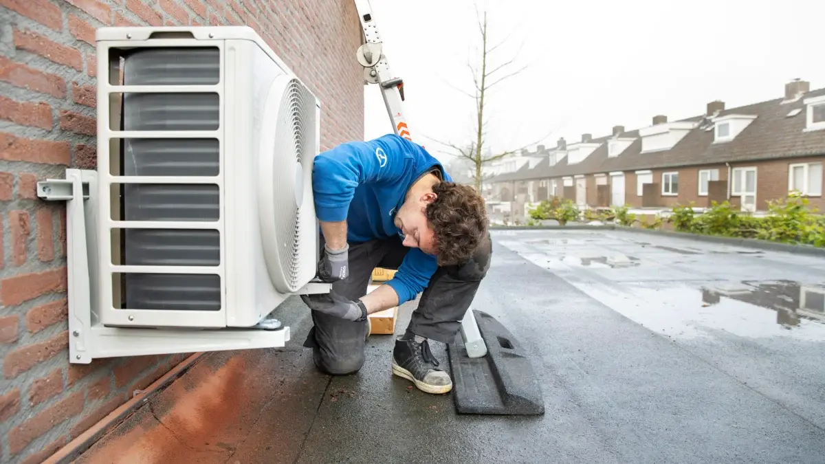 Installateur van warmtepomp die aan een warmtepomp sleutelt