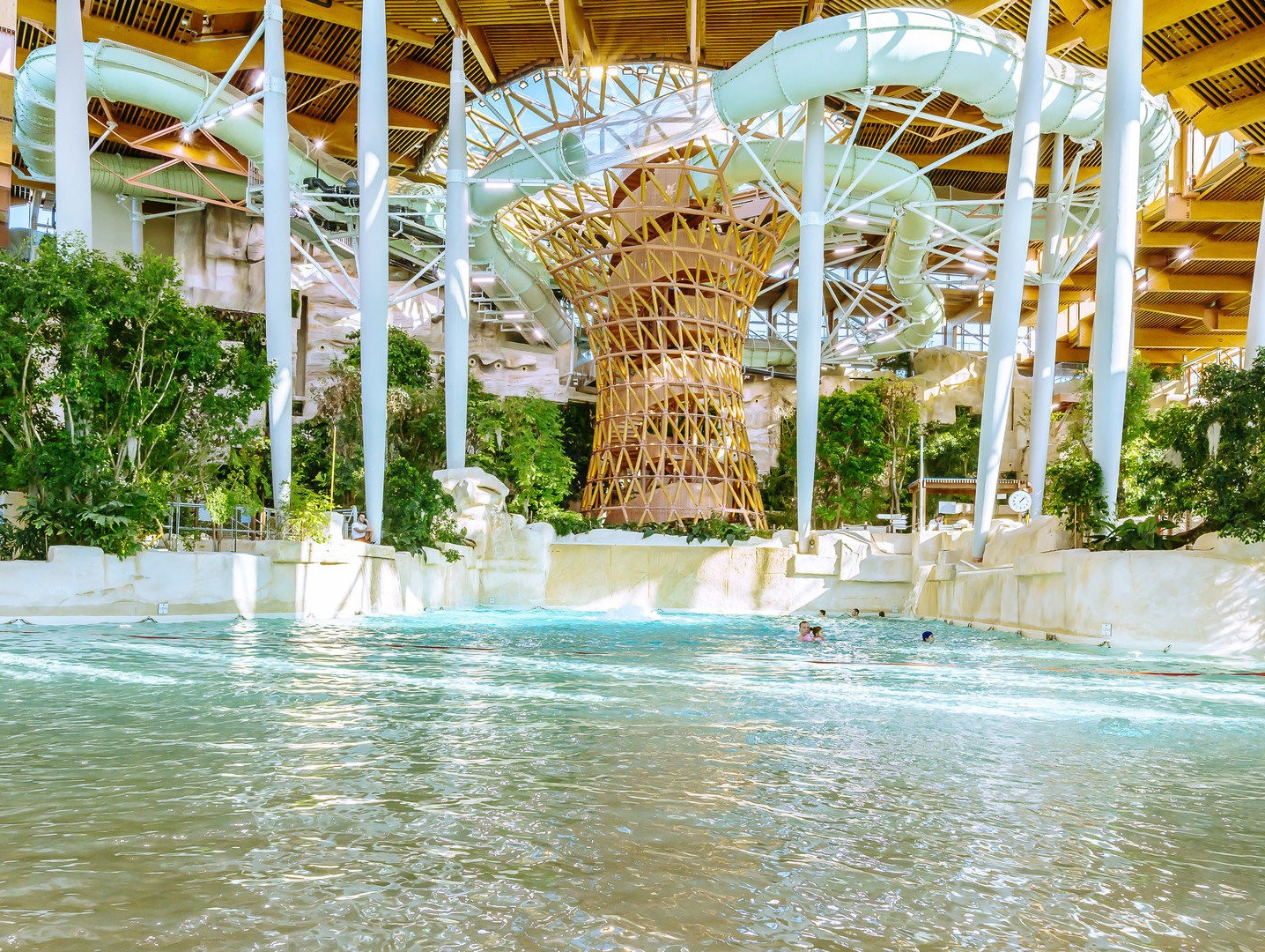 Centre Parcs intérieur tropical avec toboggans et végétation luxuriante.