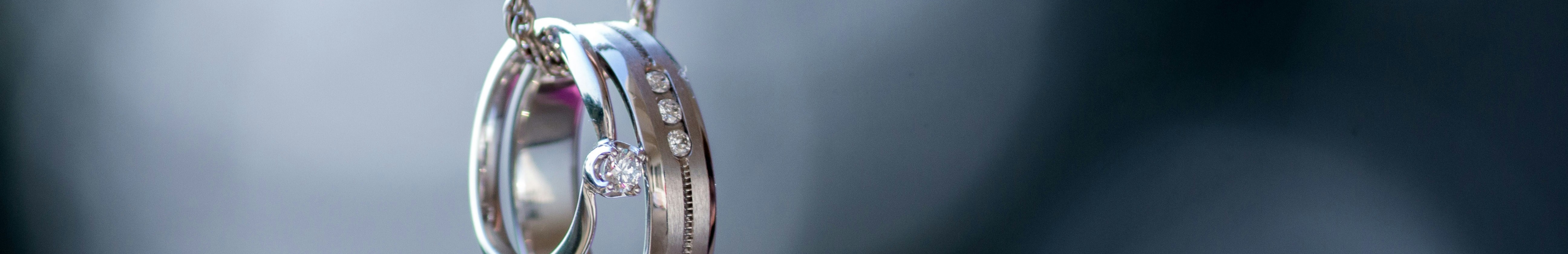 Bagues en argent avec diamant portées sur une chaine.