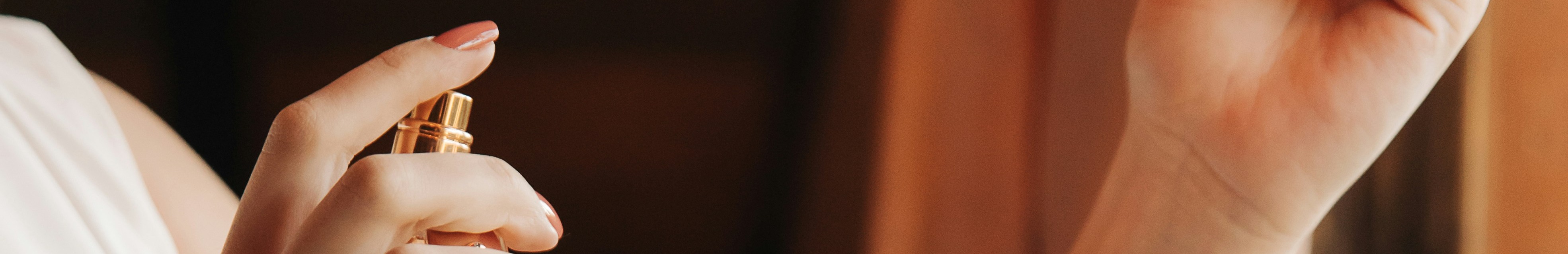 Femme qui tient une bouteille de parfum dans la main.