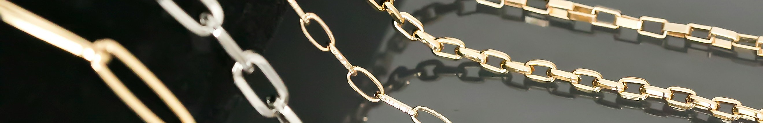 Chaînes en argent et en or posées côte à côte.