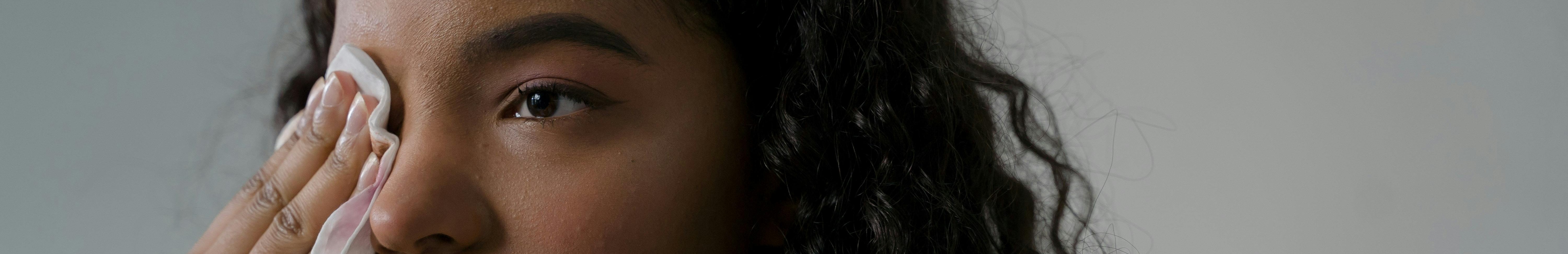 Femme qui retire son maquillage à l'aide d'une lingette.