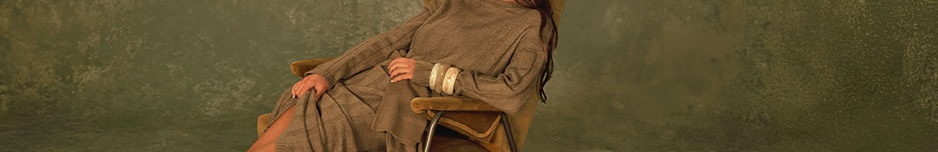 Femme élégante en robe pull beige foncé et bottes assorties.